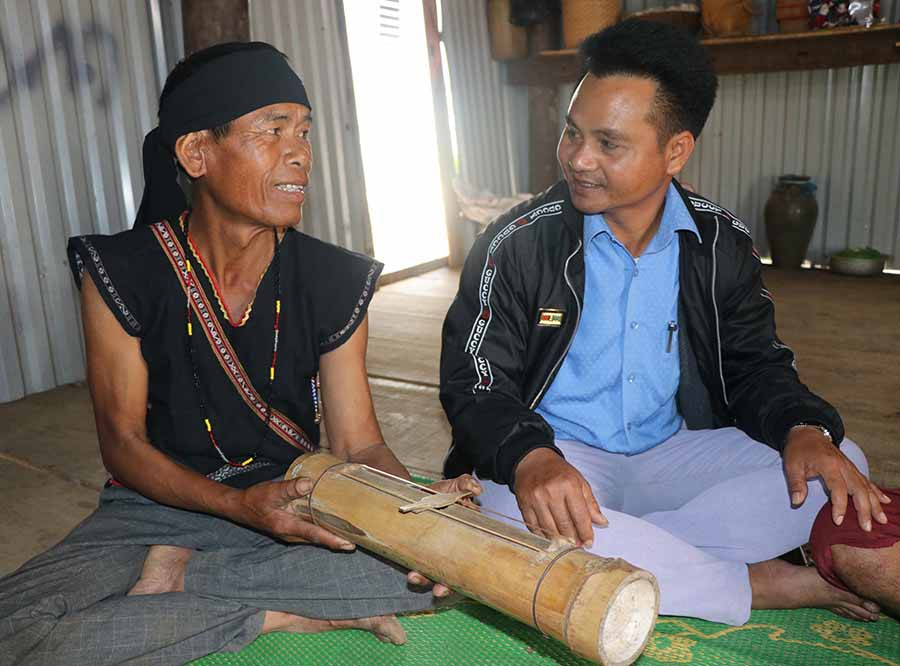  Ông Đinh A Nghinh (bìa trái) giới thiệu cách làm trống tre. Ảnh: N.M