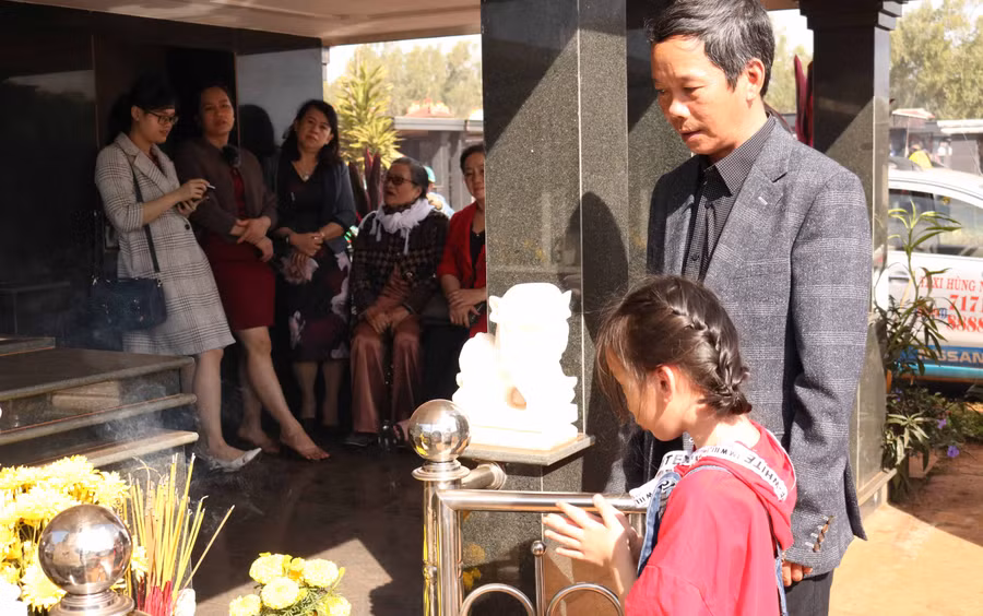 Anh Lê Thúc Thuyên (tổ 5, phường Hội Phú, TP. Pleiku) hướng dẫn hai con thắp hương cho ông nội. Ảnh: Ngọc Sang