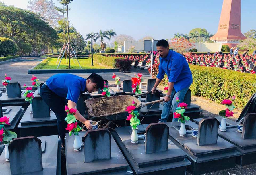  Đoàn viên thay cát tại phần mộ các liệt sĩ ở Nghĩa trang liệt sĩ tỉnh. Ảnh Phan Lài 