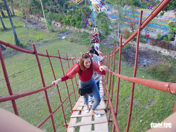 Du khách sau khi cúng chùa Lầu đều leo lên cầu tre để thử cảm giác - Ảnh: BỬU ĐẤU