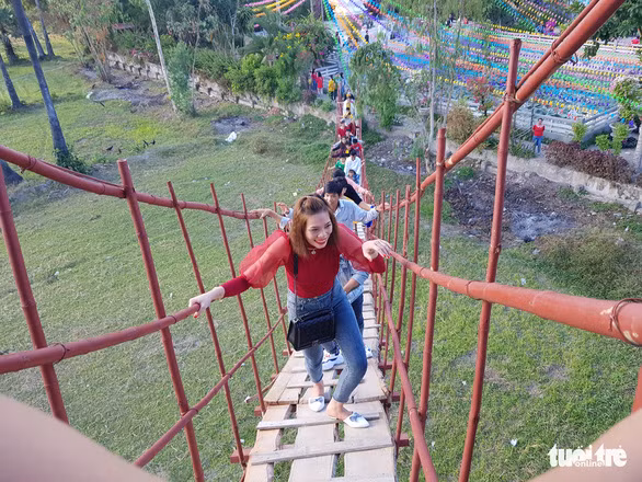 Du khách sau khi cúng chùa Lầu đều leo lên cầu tre để thử cảm giác - Ảnh: BỬU ĐẤU