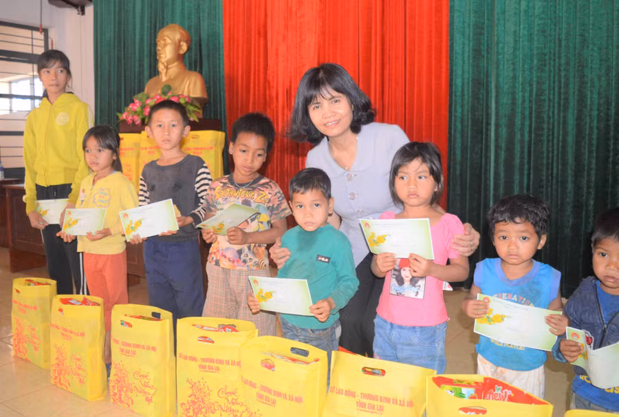 Bà Rcom Sa Duyên tặng quà cho trẻ em nghèo xã Ia Pnôn. Ảnh: Đinh Yến