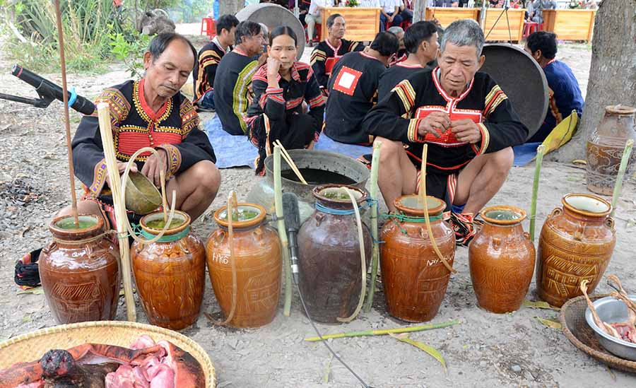  Già làng Rô Ngớt (bìa trái) rót nước vào các ghè rượu lễ vật. Ảnh: Đ.P