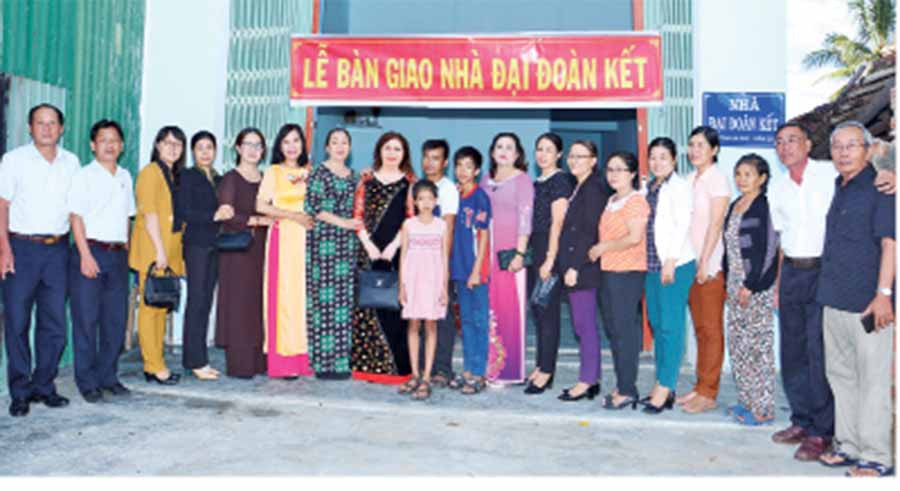  Chị Lâm Thị Liễu (thứ 8 từ trái sang) cùng chính quyền địa phương giúp đỡ, xây nhà cho người nghèo.