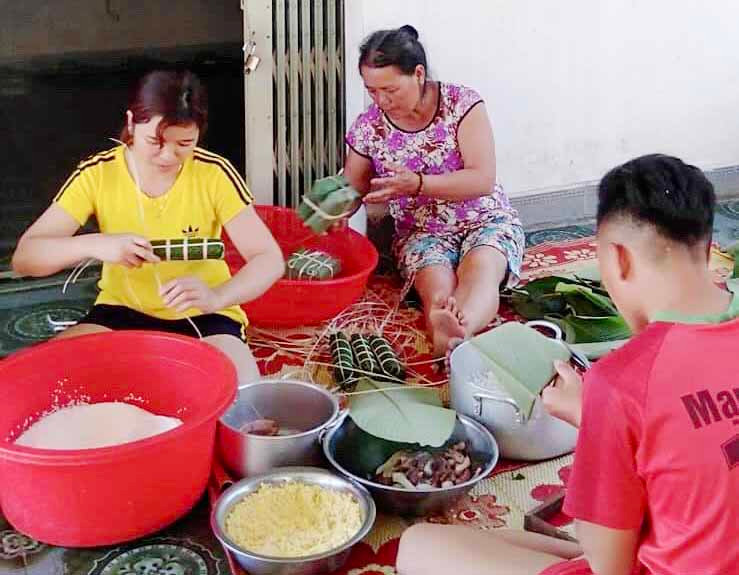 Một gia đình người Mường gói bánh tét ăn Tết. Ảnh: Lê Hòa