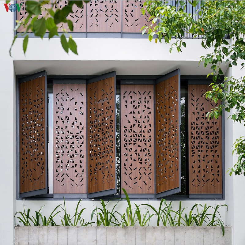 Điểm gây chú ý duy nhất là những cánh cửa gỗ màu nâu trổ những hình tam giác đầy ngẫu hứng Điểm gây chú ý duy nhất là những cánh cửa gỗ màu nâu trổ những hình tam giác đầy ngẫu hứng