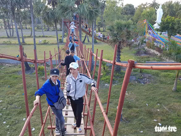 Du khách đi cầu tre ở chùa Lầu để thử cảm giác 