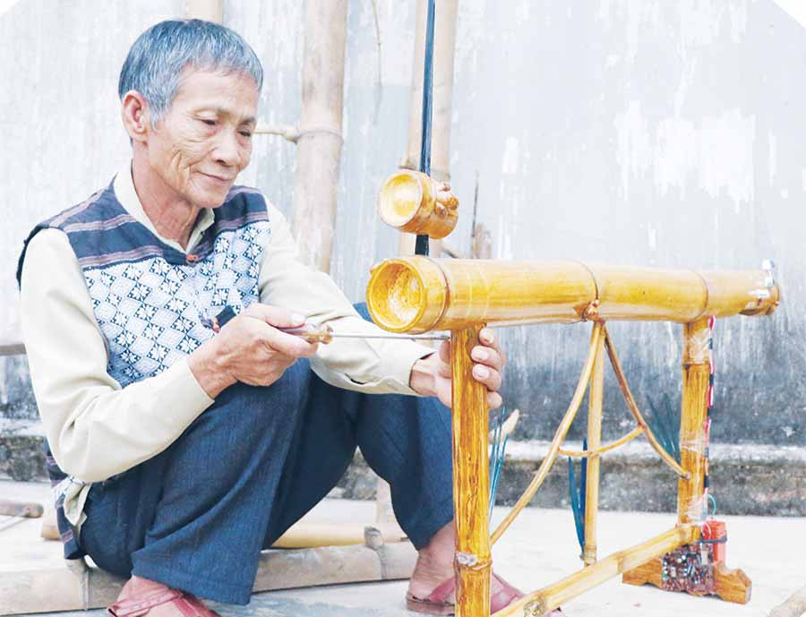 Ông Mai Hào Hùng chế tác đàn bầu từ thân cây tre có dáng dấp nhà rông Tây Nguyên. Ảnh: N.M