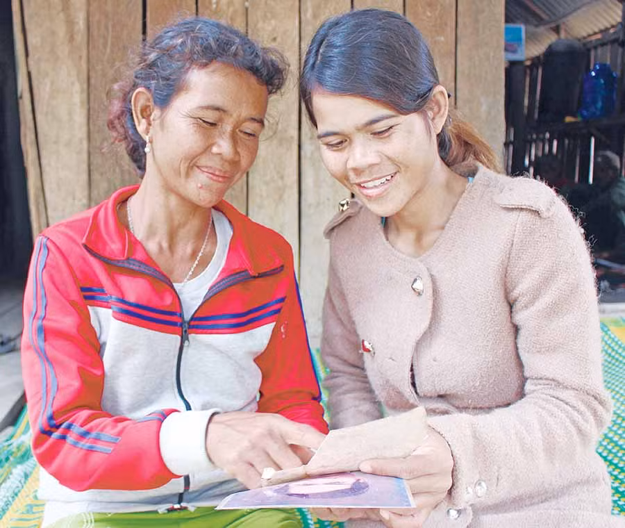 Chị Đinh Thị Luy (bìa trái) cùng con gái ôn lại kỷ niệm với ông Phạm Hồng. Ảnh: H.T