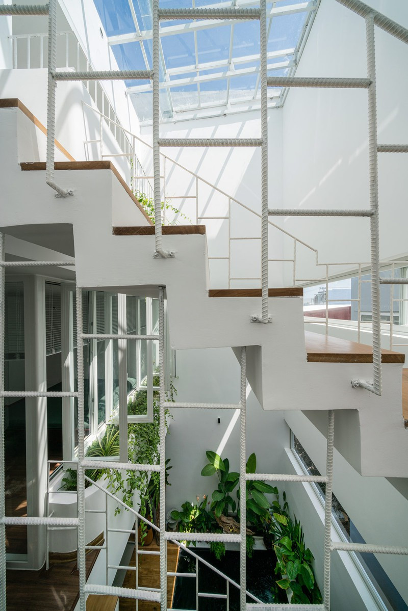 Một chiếc lan can bằng kim loại đặt chéo bên cạnh cầu thang, phù hợp với giếng trời.