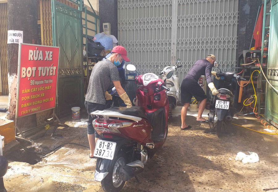 Rửa xe máy bọt tuyết là dịch vụ đông khách chiều 30 Tết. Ảnh: Đinh Yến