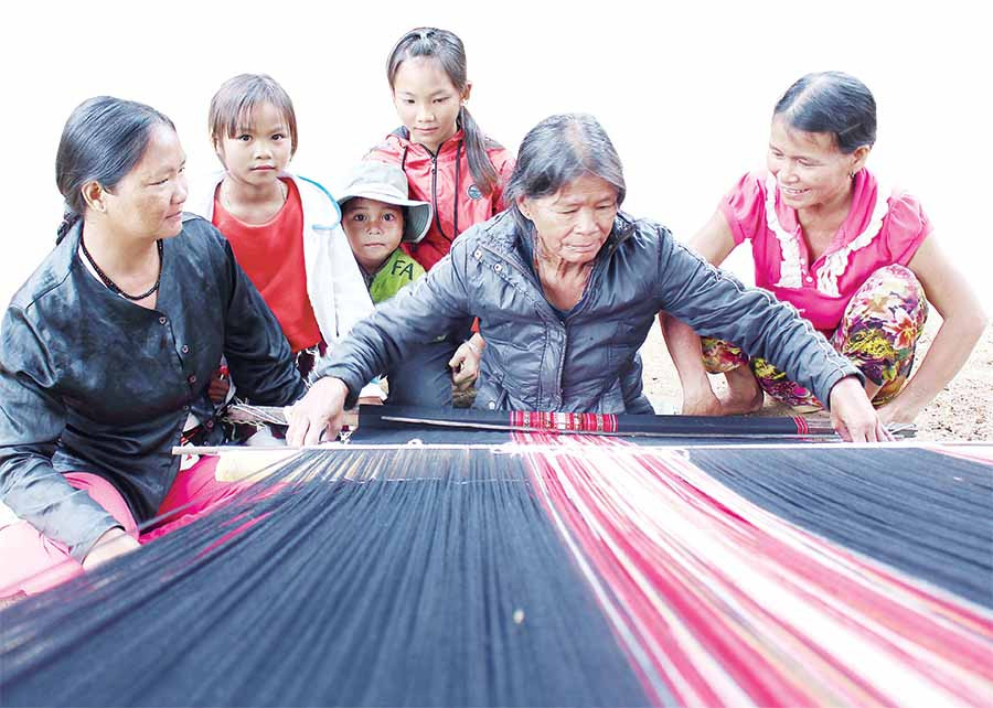 Bà Đinh Thị Gép-con dâu nuôi của ông Phạm Hồng-chỉ dạy con cháu cách dệt thổ cẩm. Ảnh: H.T Bà Đinh Thị Gép-con dâu nuôi của ông Phạm Hồng-chỉ dạy con cháu cách dệt thổ cẩm. Ảnh: H.T