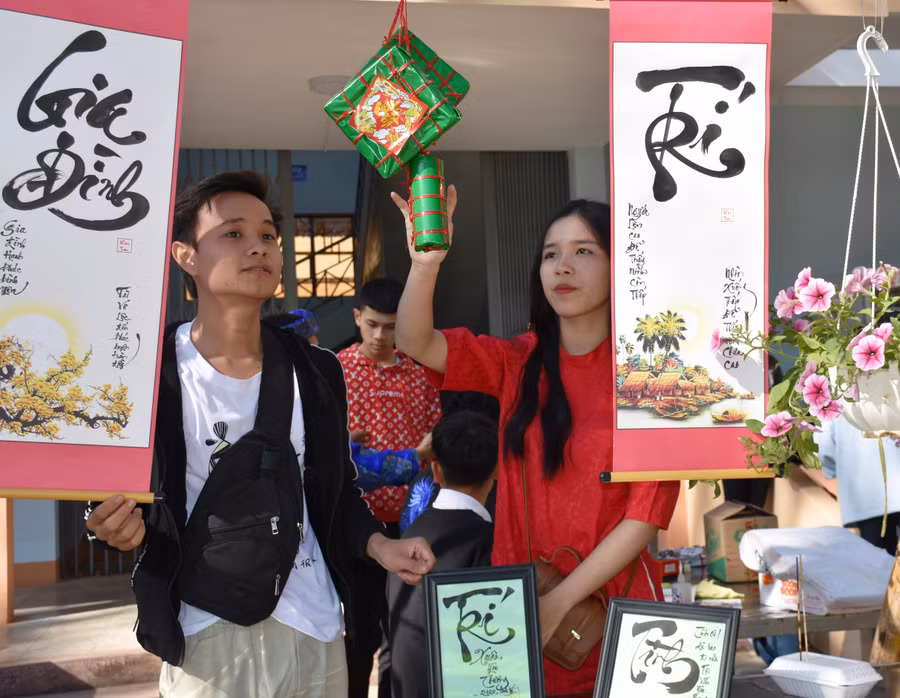 Các em học sinh thích thú với gian hàng Thư pháp Việt. Ảnh: Trần Dung