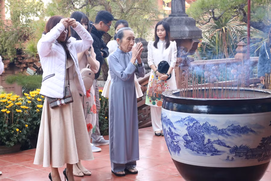  Bà Nguyễn Thị Nữ cùng các con, cháu đi lễ đầu năm cầu mong năm mới mọi sự tốt lành đến với gia đình. Ảnh: Ngọc Sang