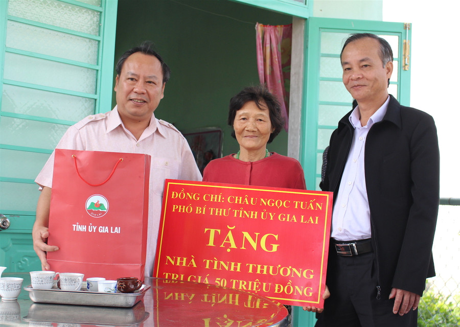 Phó Bí thư Tỉnh ủy Châu Ngọc Tuấn (trái) trao tặng nhà tình nghĩa và quà Tết cho gia đình bà Trịnh Thị Hoa. Ảnh Mộc Trà