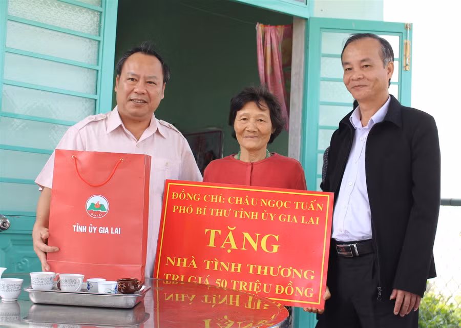Phó Bí thư Tỉnh ủy Châu Ngọc Tuấn (trái) trao tặng nhà tình nghĩa và quà Tết cho gia đình bà Trịnh Thị Hoa. Ảnh Mộc Trà