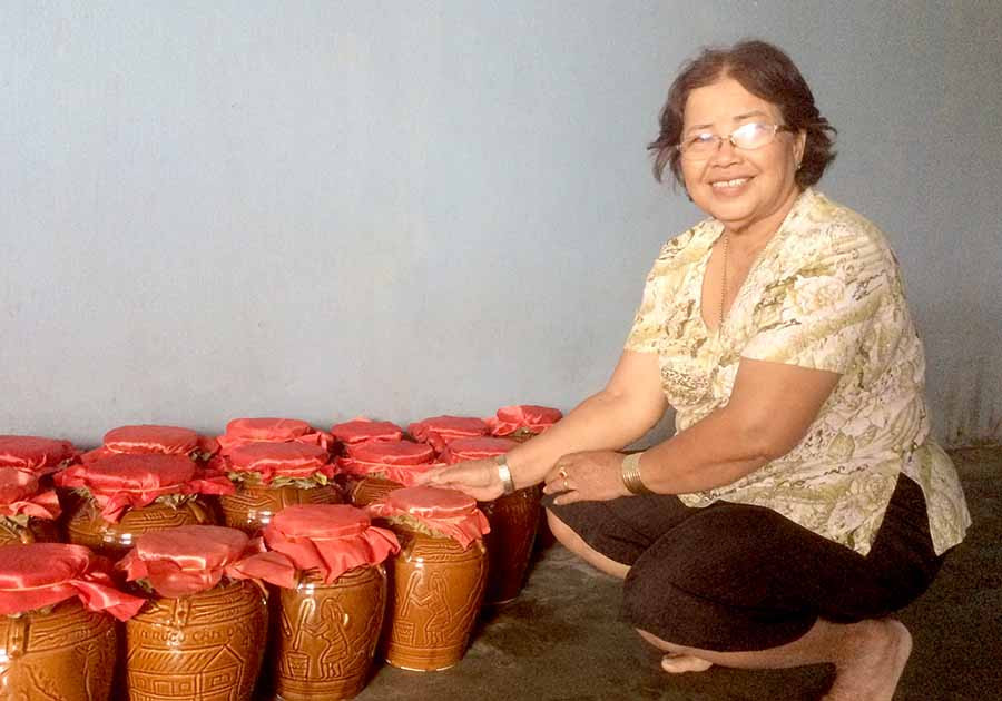 Bà H'Phiên bên những ghè rượu thành phẩm. Ảnh: N.H Bà H'Phiên bên những ghè rượu thành phẩm. Ảnh: N.H