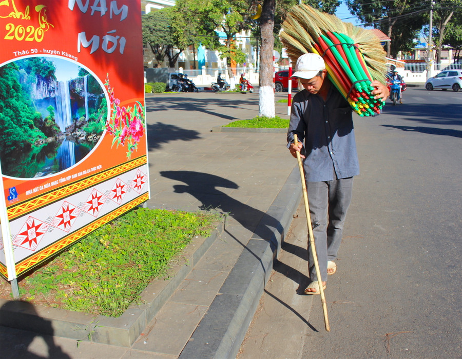 Chàng trai khiếm thị Nông Văn Cường tranh thủ đi bán chổi trong những ngày cuối năm. Ảnh: Mộc Trà