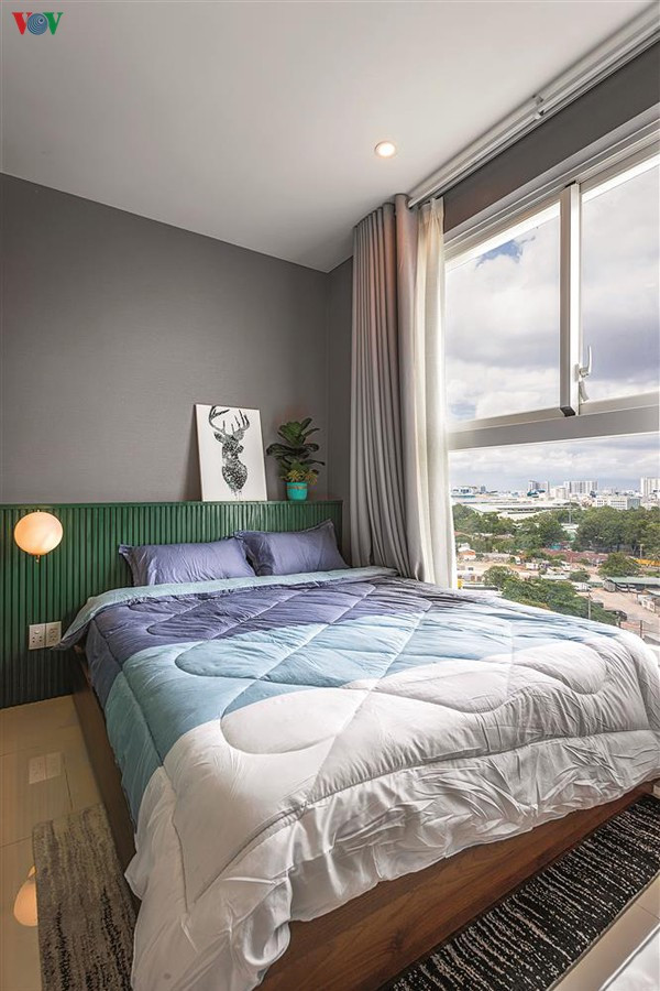Phòng ngủ nhỏ chan hòa ánh sáng thiên nhiên với mảng đầu giường màu xanh lá.