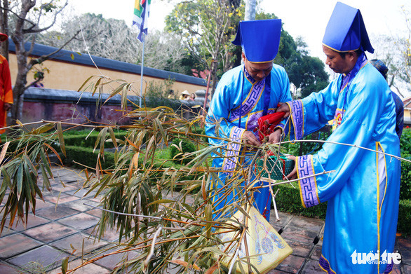 Ấn triện, quà, bùa...được treo trên đỉnh cây nêu - Ảnh: NHẬT LINH