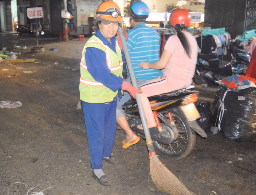 Ngay trước giờ giao thừa, chị Vũ Thị Lâm vẫn miệt mài công việc của mình trên phố. Ảnh: Đinh Yến
