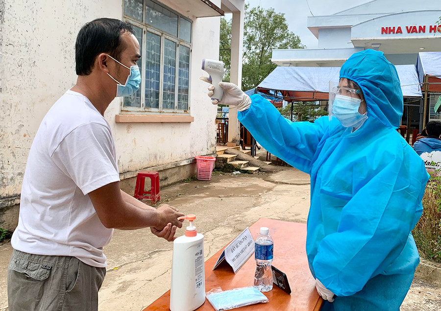 Người dân xã Tân Sơn (TP. Pleiku) đo thân nhiệt sát khuẩn tay trước khi vào khu vực tiêm chủng. Ảnh: Như Nguyện Người dân xã Tân Sơn đo thân nhiệt sát khuẩn tay trước khi vào khu vực tiêm chủng. Ảnh: Như Nguyện