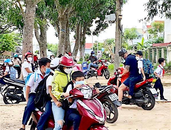 Tình trạng phụ huynh chở con trên xe máy không đội mũ bảo hiểm vẫn còn diễn ra hàng ngày tại các địa phương trong tỉnh. Ảnh: Mộc Trà