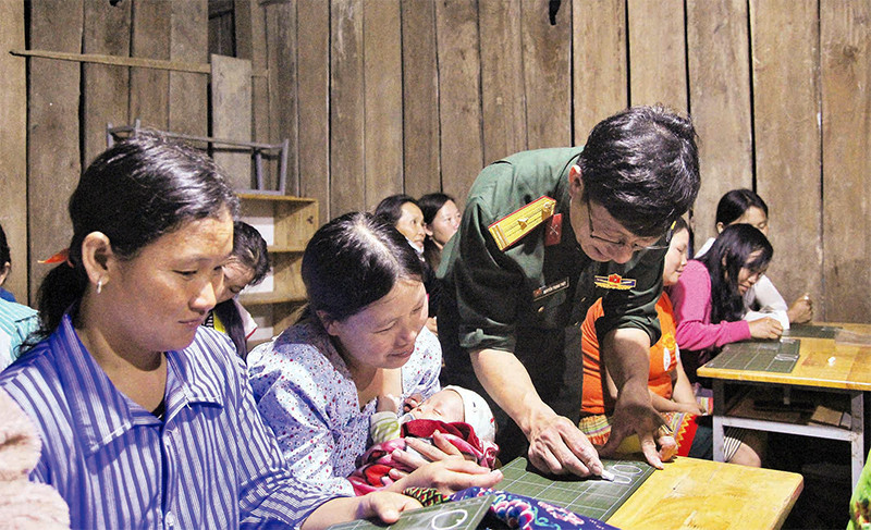 Thiếu tá Nguyễn Trọng Thúy hướng dẫn cho bà con Tiểu khu 179 viết chữ.