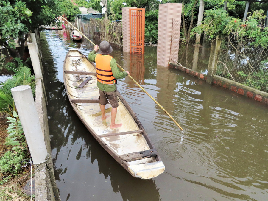 Người dân di chuyển bằng đò trong ngõ xóm ở Thạch Trung, trong khi chỉ cách mấy bước chân là QL1 khô ráo. Ảnh: Trương Quang Nam Người dân di chuyển bằng đò trong ngõ xóm ở Thạch Trung, trong khi chỉ cách mấy bước chân là QL1 khô ráo. Ảnh: Trương Quang Nam
