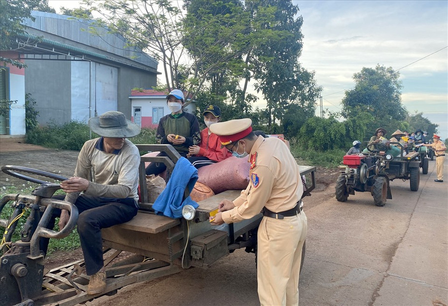 Cảnh sát giao thông Công an huyện Đắk Mil dán decal cho xe máy cày. Ảnh: Phan Tuấn