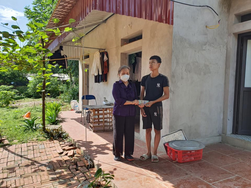 Bà Thuận trao tiền hỗ trợ cho một học sinh được Hội đỡ đầu.