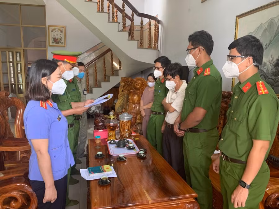  Ông Đoàn Thế Nam (nguyên Hiệu trưởng Trường Cao đẳng nghề Bình Phước) áo trắng thứ 3, bên phải nghe lực lượng chức năng đọc quyết định khởi tố. Ảnh: H.G