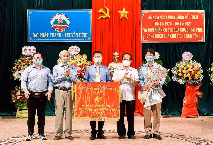 Chủ tịch UBND tỉnh Võ Ngọc Thành trao cờ của Chính phủ cho tập thể cán bộ CNV đài phát thanh truyền hình nhân kỷ niệm 45 ngày phát sóng. Ảnh: Đức Thụy