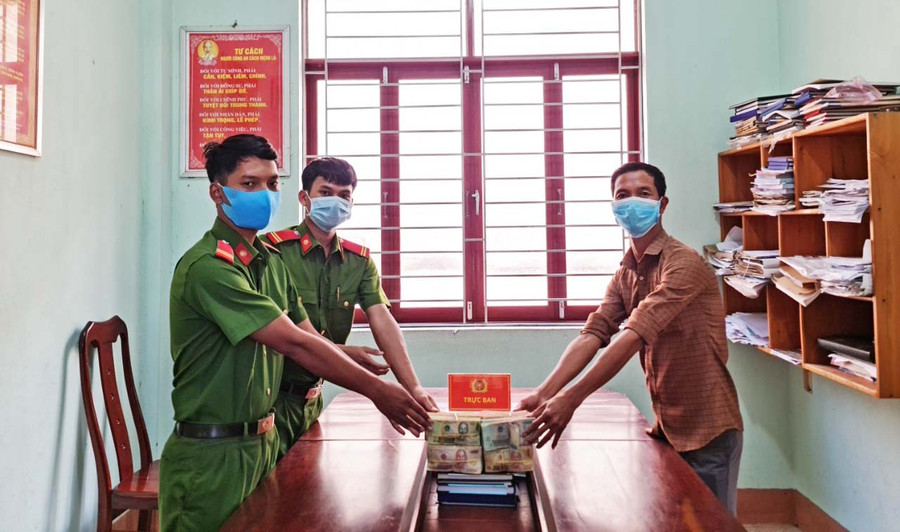 Trung sĩ Phạm Hoài Nam và Hạ sĩ Ksor Vi trao trả số tiền 505 triệu đồng cho người đánh rơi. Ảnh: Nguyễn Sang