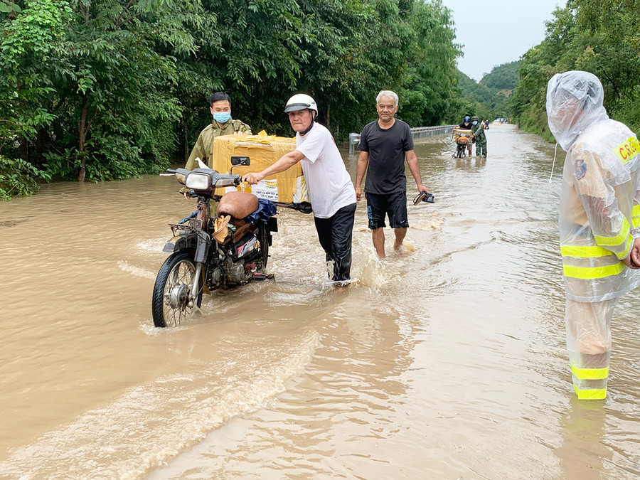 Lực lượng chức năng điều tiết giao thông tại khu vực bị ngập úng trên quốc lộ 25, đoạn qua đèo Tô Na (thuộc địa phận xã Ia Rtô, thị xã Ayun Pa). Ảnh: Vũ Chi Mực nước dâng cao khiến các xe máy buộc phải quay đầu, chỉ có xe tải, xe bán tải gầm cao được tạo điều kiện đi qua. Ảnh: Vũ Chi