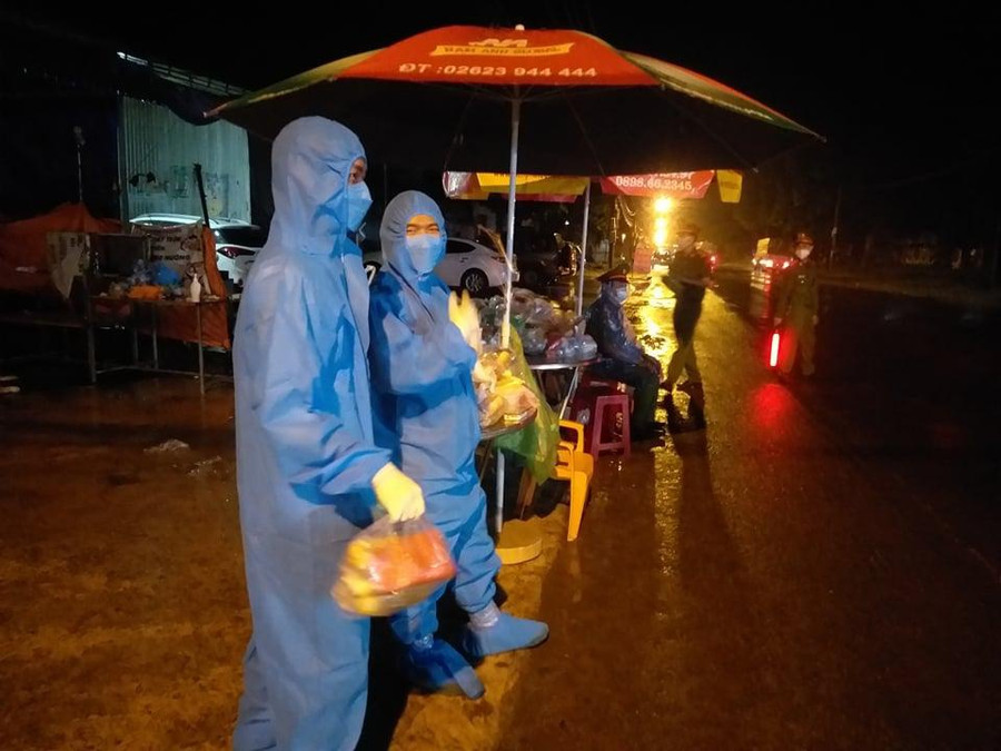 Các thành viên nhóm SOS Buôn Ma Thuột hỗ trợ phát nhu yếu phẩm cho người dân hồi hương tại chốt kiểm dịch Hòa Phú trên QL14. Ảnh: NVCC