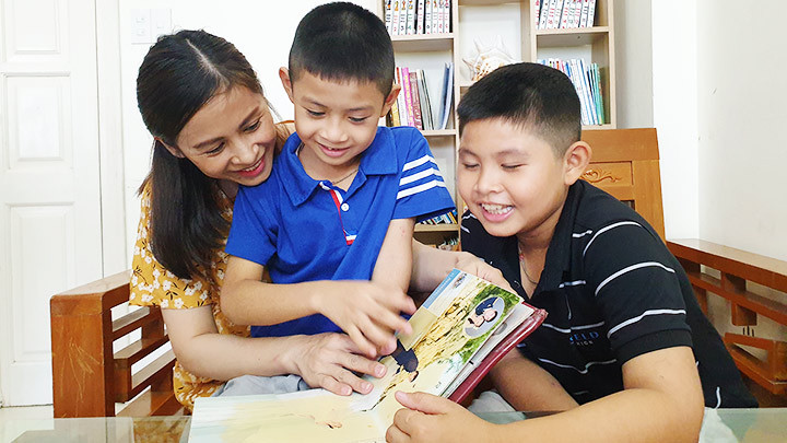 Mẹ con chị Lê Thị Ngân cùng xem lại album ảnh gia đình. 