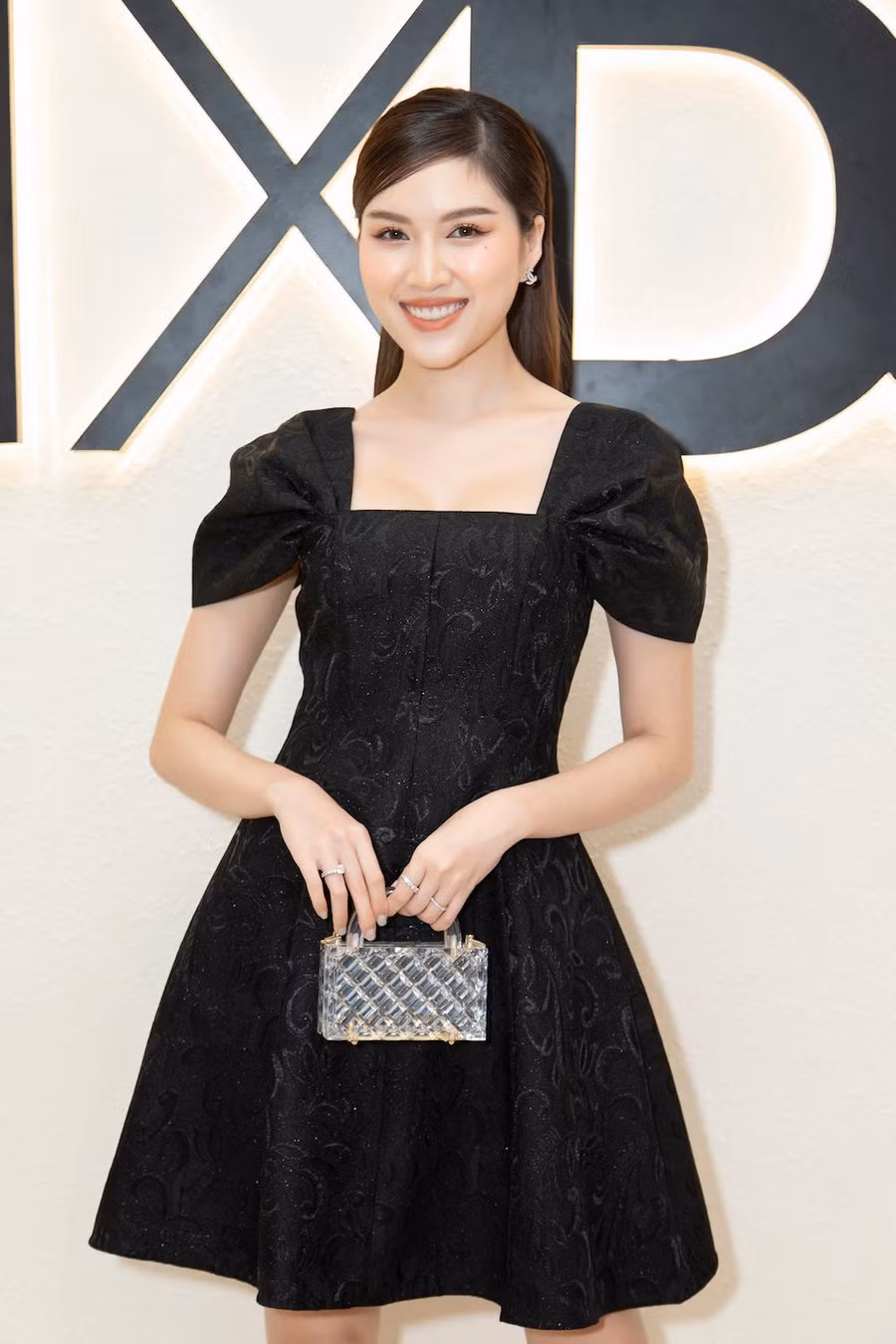 MC Thanh Thanh Huyền điệu đà với váy xòe ngắn trên gối. Cô mang túi cầm tay trong suốt giúp trang phục thêm bắt mắt. Dù được nhiều người kỳ vọng tham gia Hoa hậu Hoàn vũ Việt Nam song người đẹp quyết định từ chối vì thấy bản thân hợp với vai trò MC hơn. Ảnh: Huy Nguyễn, Đinh Trung Tín