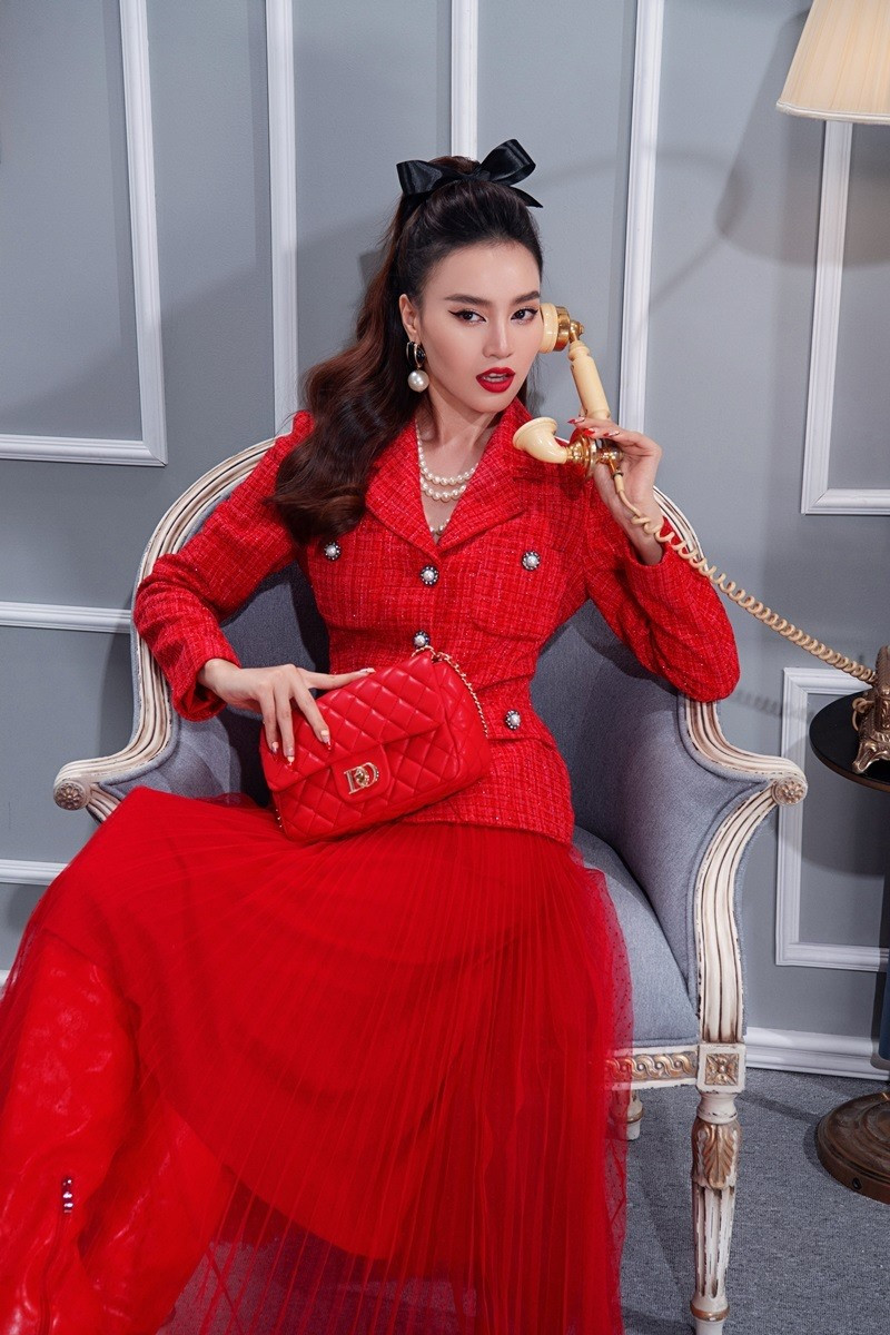 Áo vải tweed kết hợp chân váy xếp ly dài tới mắt cá chân tông đỏ giúp cô nàng trông quý phái, quyền lực.