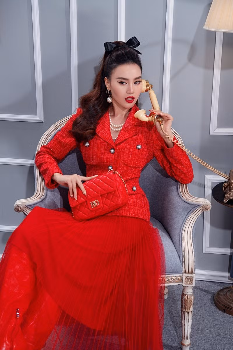 Áo vải tweed kết hợp chân váy xếp ly dài tới mắt cá chân tông đỏ giúp cô nàng trông quý phái, quyền lực.