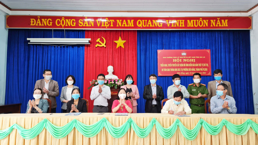 Đại diện 3 hộ gia đình tiêu biểu của phường Diên Hồng ký Bản đăng ký gia đình đảm bảo trật tự ATGT. Ảnh: Bá Bính