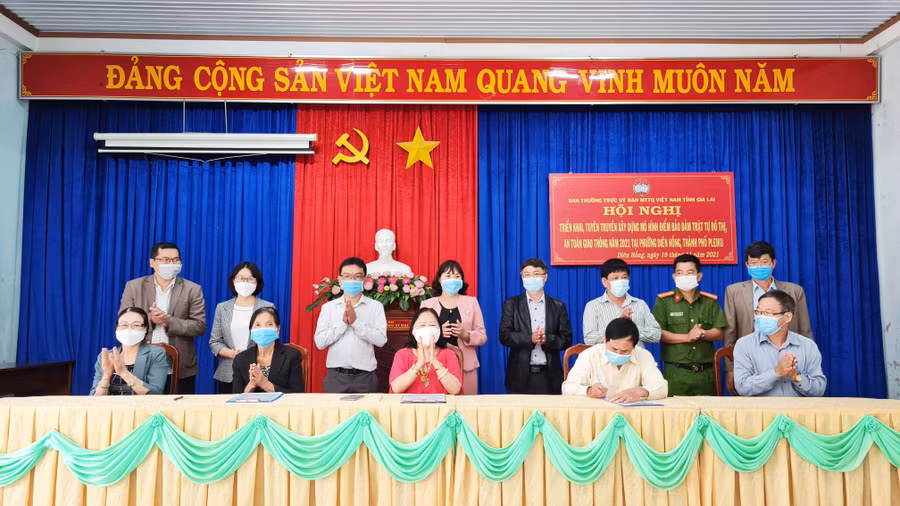 Đại diện 3 hộ gia đình tiêu biểu của phường Diên Hồng ký Bản đăng ký gia đình đảm bảo trật tự ATGT. Ảnh: Bá Bính