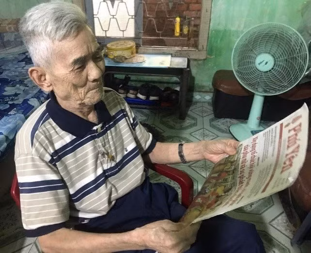Lúc rảnh ông Luyện thường đọc báo xem tin tức. Ảnh: KHÔI NGUYÊN