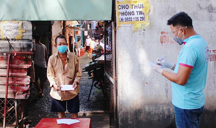 Người dân trong khu trọ ở hẻm 3/2 Nguyễn Văn Săng nhận quà từ nhà hảo tâm hồi tháng 9.2021. Ảnh: Đào Nguyên