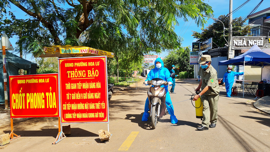 Lực lượng chức năng phun khử khuẩn người ra vào khu vực tạm thời phong tỏa làng Plei Ốp (phường Hoa Lư, TP. Pleiku). Ảnh: Bá Bính