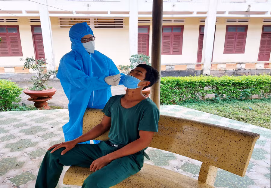 Nhân viên y tế lấy mẫu xét nghiệm cho người trong khu cách ly. Ảnh: Vĩnh Hoàng