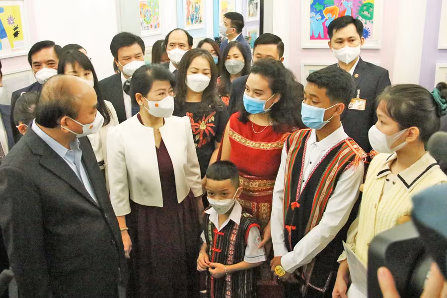 Chủ tịch nước Nguyễn Xuân Phúc ân cần trò chuyện cùng 3 mẹ con ca sĩ Y Byen tại buổi triển lãm (ảnh nhân vật cung cấp).