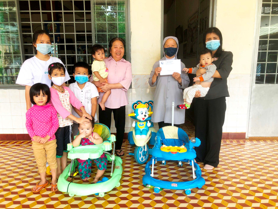 Bà Rcom Sa Duyên (bìa phải)-Giám đốc Sở Lao động-Thương binh và Xã hội thăm, tặng quà trẻ em mồ côi tại Nhà trẻ Sao Mai (TP. Pleiku). Ảnh: Đinh Yến