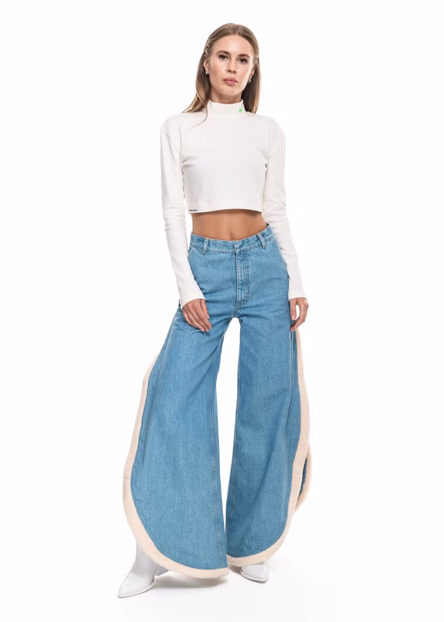 Quần denim ống rộng thoải mái với đường xẻ dài viền lông màu trắng.