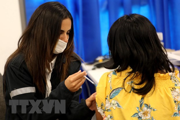 Nhân viên y tế Israel tiêm vaccine phòng COVID-19 cho người dân. Ảnh: THX/TTXVN